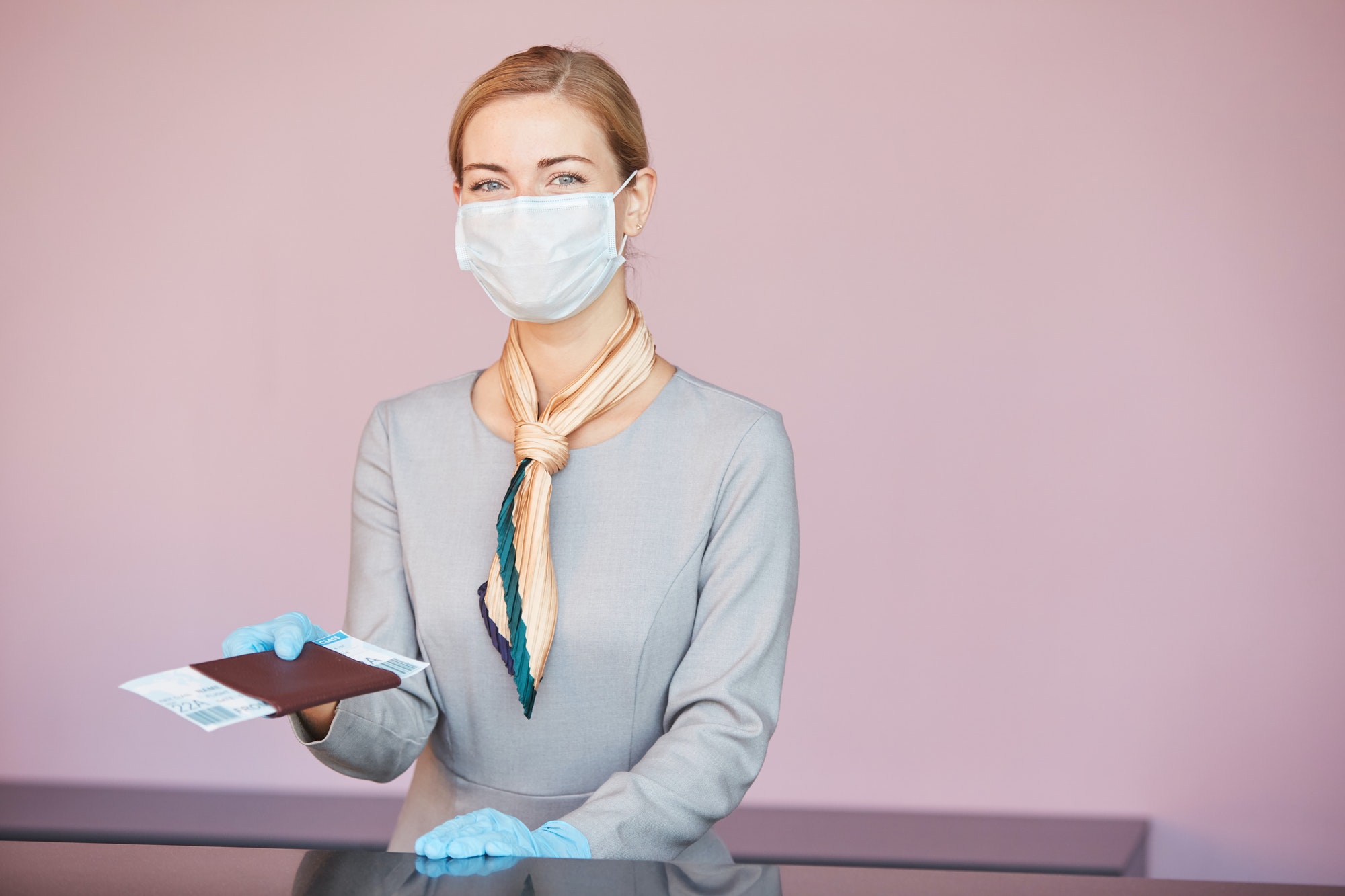 Blonde Woman Wearing Mask at Check In Desk in Airport